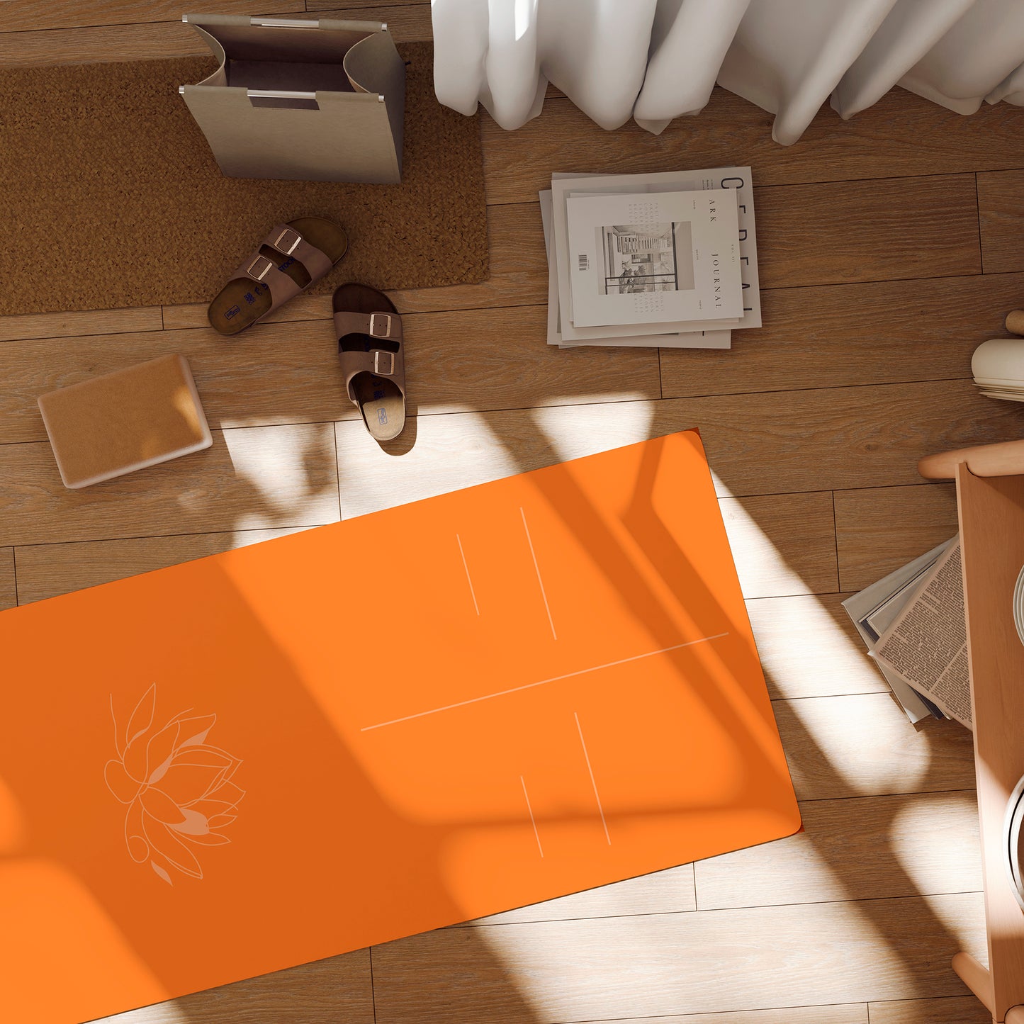 Orange suede yoga mat with a lotus flower and alignment lines lying on the floor