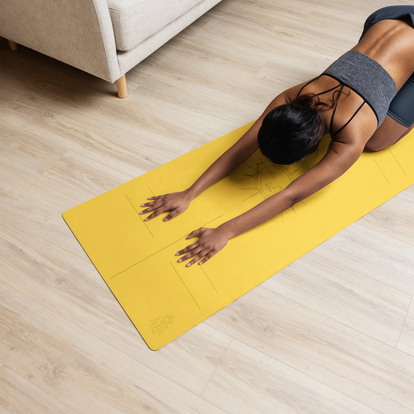 Woman practicing yoga on a yellow suede yoga mat with a sun design and alignment lines
