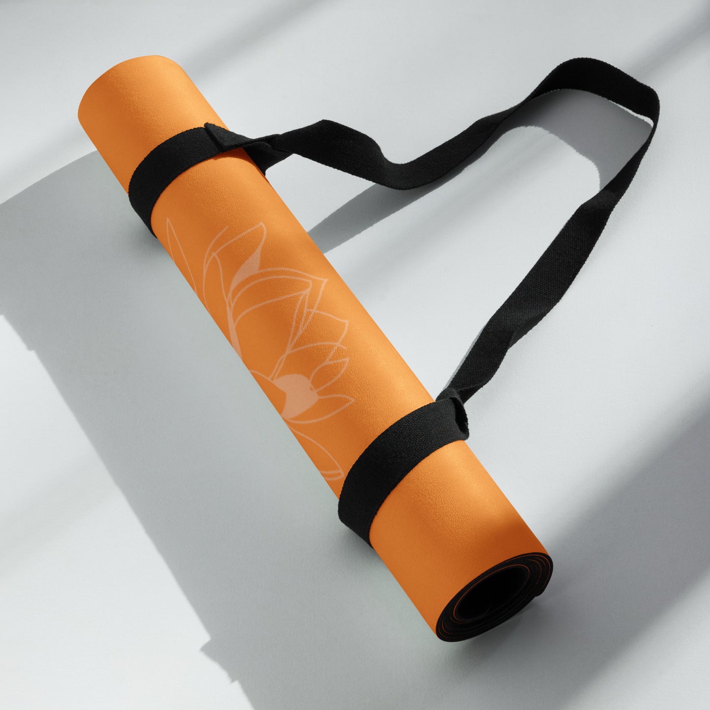 Rolled up orange suede yoga mat with a carrying strap