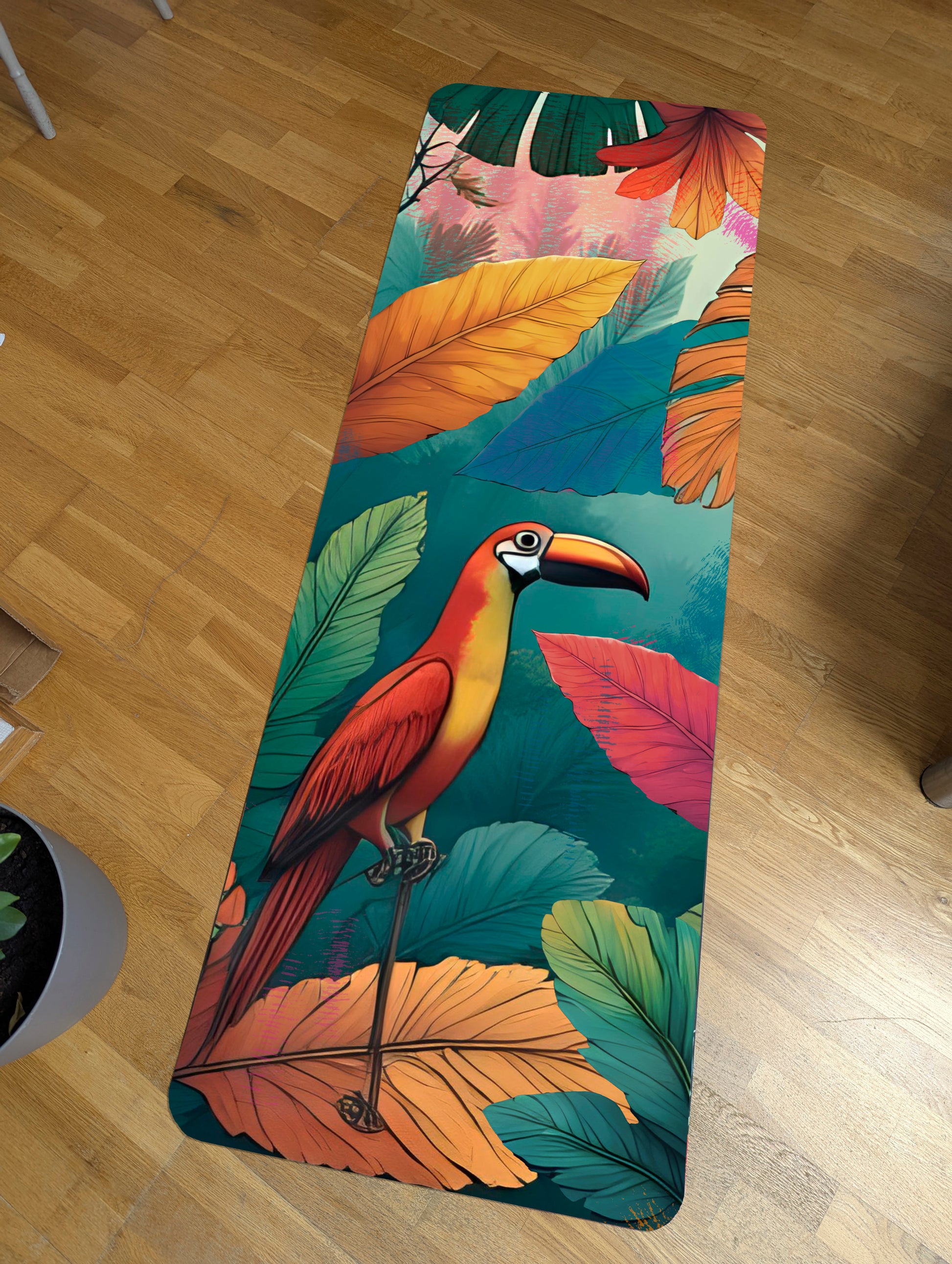 Yoga mat with a colorful parrot design on a wooden floor. Suede mircofibre top and anti slip rubber bottom.